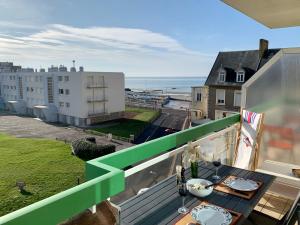 d'un balcon avec une table et une vue sur l'océan. dans l'établissement Ninou Cap Sud, terrasse vue mer, appt lumineux 66m2, à Wimereux
