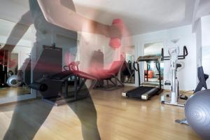 a room with a gym with red chairs and a treadmill at Aegean Suites in Megali Ammos