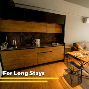 a kitchen with wooden cabinets and a table and a dining room at The Kayseri Loft Hotel in Kayseri