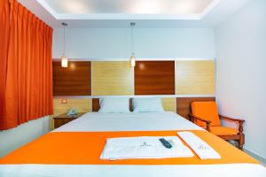 een slaapkamer met een bed met een oranje deken bij Hotel Nilas in Tarapoto