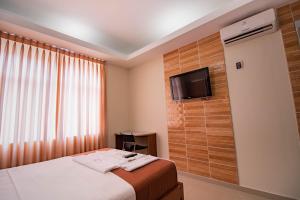 pokój hotelowy z łóżkiem i telewizorem w obiekcie Hotel Nilas w mieście Tarapoto