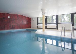 una gran piscina con suelo de baldosa azul y ventanas en Am Waltenberg 70-KO, en Winterberg
