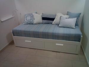 un letto con cuscini sopra di esso in una camera di La Casa Delle Conchiglie a Trapani