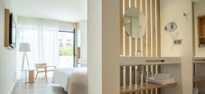 a hotel room with a bed and a mirror at Instants Boutique Hotel - Adults Only in Cambrils