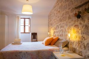 een slaapkamer met een bed en een stenen muur bij Farinera Vella in Santanyi