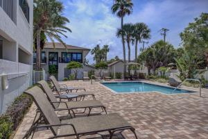 a group of chairs sitting next to a swimming pool at Siesta Sands Beach Resort 4th Floor with Elevator in Sarasota +42 photos