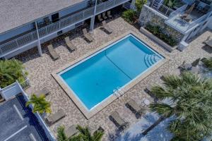 an overhead view of a swimming pool with chairs and trees at Siesta Sands Beach Resort 4th Floor with Elevator in Sarasota