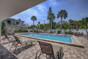 a swimming pool with rocking chairs and a swimming pool at Siesta Sands Beach Resort 4th Floor with Elevator in Sarasota