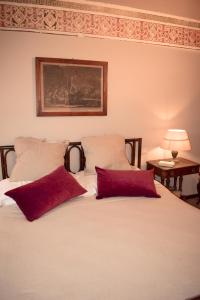 een slaapkamer met een bed met 2 rode kussens bij Il Carmine Charme & Terrace with AC in Lucca
