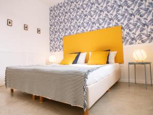 - une chambre avec un grand lit et une tête de lit jaune dans l'établissement Casa Blu Guesthouse - Maison d'hôtes, à Santa Maria