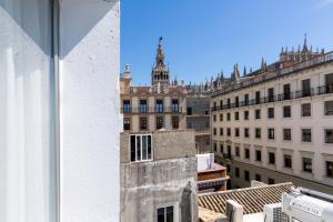 a building with a clock on the side of it at Welldone Cathedral Suites in Seville