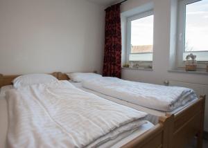 two unmade beds in a bedroom with two windows at Im Hohlen Seifen 10-H in Winterberg