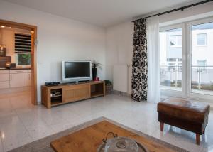 a living room with a television on a wooden entertainment center at Im Hohlen Seifen 10-H in Winterberg