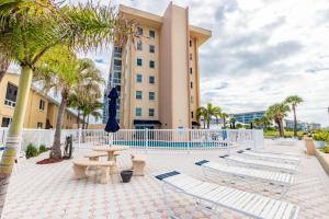 a resort building with a table and chairs and palm trees at San Marco Gulf Beach Views 3rd Floor in Venice