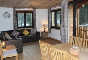 a living room with a couch and a table at Just Morzine - Chalet Luna in Morzine