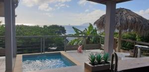 a swimming pool on a patio with a view of the ocean at Edasama in Rivière-Pilote