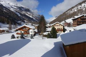 a snow covered village in the mountains with houses at Apartment Alpenblick in Saas-Grund