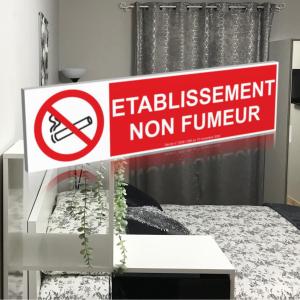 een bord in een kamer met een bed met een wegwijzer bij Studios du Rempart in Avignon