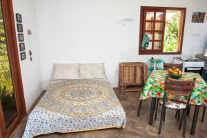 a bedroom with a bed and a table and a mirror at Recanto dos Dendês Chalés in Serra Grande