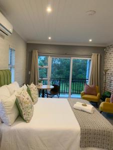 een groot wit bed in een kamer met een balkon bij Pont de Val - La Rivière Apartments in Parys