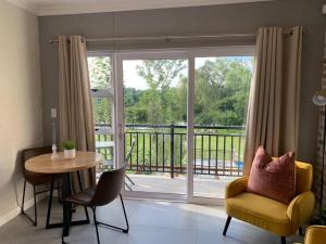 un soggiorno con tavolo e una grande finestra di Pont de Val - La Rivière Apartments a Parys