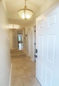 een hal met een witte deur en een tegelvloer bij Seaside at Anastasia B105 in St. Augustine