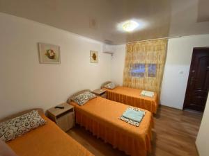 a room with two beds and a couch and a window at Guest House U Chizhika in Sevastopol