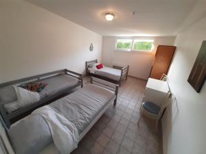 a small bedroom with a bed and a desk at Gîte la Taniere Le jersey in Moidrey