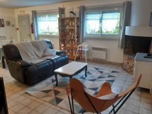 a living room with a couch and chairs and a table at Gîte la Taniere Le jersey in Moidrey