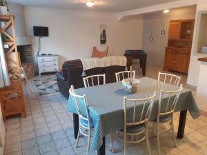 a living room with a table and chairs and a couch at Gîte la Taniere Le jersey in Moidrey