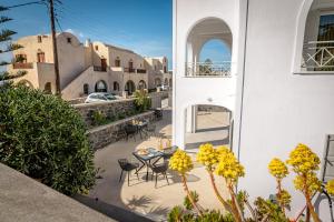 een patio met stoelen en een tafel in een gebouw bij Thealos Santorini in Pirgos