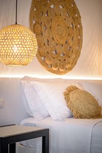 a room with a bed with a lamp and a basket at Thealos Santorini in Pirgos