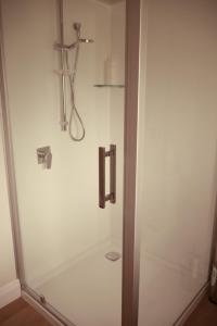 a shower stall in a bathroom with a sink at Apartment on St Georges in Havelock North +8 photos