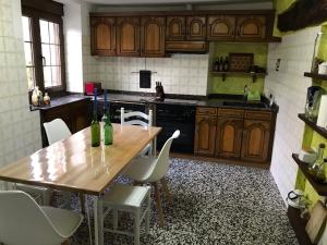 cocina con mesa de madera y algunas sillas en Vitori's House Tourist Accommodation, en Ahedo
