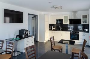 a kitchen with white cabinets and a table and chairs at Glindower Alpen Pension in Werder