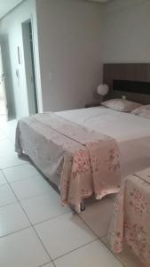 1 dormitorio con 1 cama grande con sábanas rosas en Lagoa Quente Flat Service, en Caldas Novas