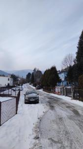 a car parked on a snow covered road at Alfa 2 apartament 3 in Bystra