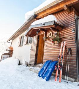 a pair of skis and ski poles next to a cabin at Vila Carmen kuća za odmor sa wellnessom,Sunger in Mrkopalj