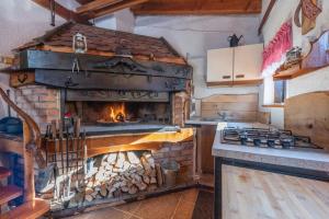 cocina con horno de ladrillo y chimenea en Vila Carmen Holiday mountain house With jacuzzi and sauna en Mrkopalj