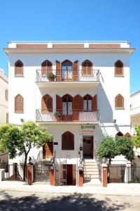 Un grand bâtiment blanc avec balcon est disponible. dans l'établissement B&B Villa Passiaturo, à Peschici