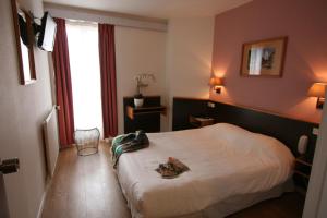 una camera d'albergo con un letto con scarpe di Denfert-Montparnasse a Parigi