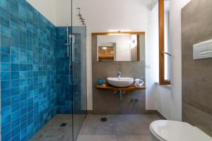 La salle de bains est pourvue d'un lavabo et d'une douche en verre. dans l'établissement Villa la Quercia, à Meta