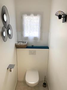 un piccolo bagno con servizi igienici e finestra di Olivier a Dauphin