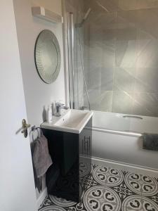 uma casa de banho com um lavatório, uma banheira e um espelho. em Rosslare Wexford em Saint Helens