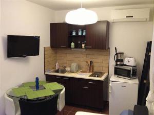 małą kuchnię ze stołem i kuchenką mikrofalową w obiekcie Apartment- Villa 6 w Siófoku