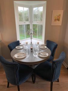 a dining room table with chairs and a table and a window at Rosslare Wexford in Saint Helens