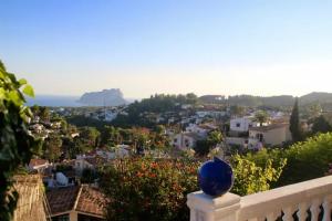 un jarrón azul sentado en una valla con vistas a una ciudad en Charming Villa in Montemar with private pool and sea views, en Benissa