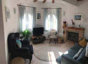 Una sala de estar con un sofá y una chimenea. en Charming Villa in Montemar with private pool and sea views, en Benissa