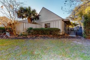 a house with a palm tree in front of it at Queens Grant 653 in Hilton Head Island