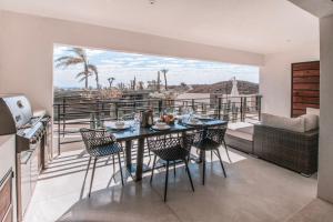 a dining room with a table and chairs on a balcony at Cerritos Surf Residences in El Pescadero